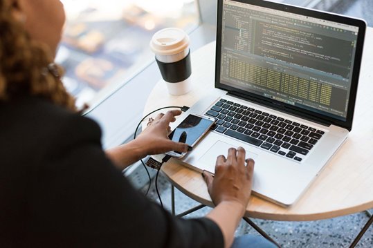 A web developer writing code on their laptop