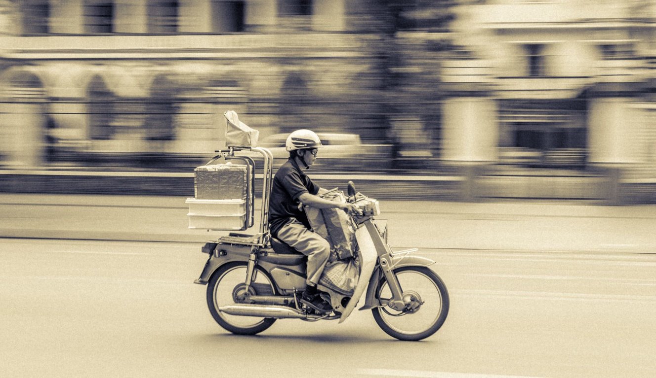 A person speeding by on a motorbike.