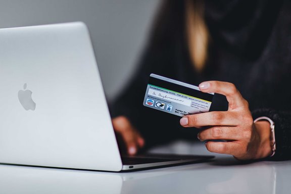 Someone using a credit card to buy something on their laptop