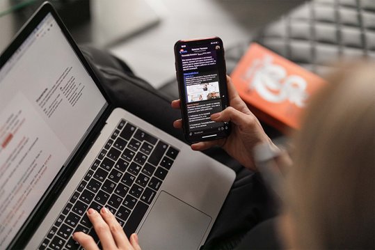 A person using their laptop and phone at the same time to accomplish a task