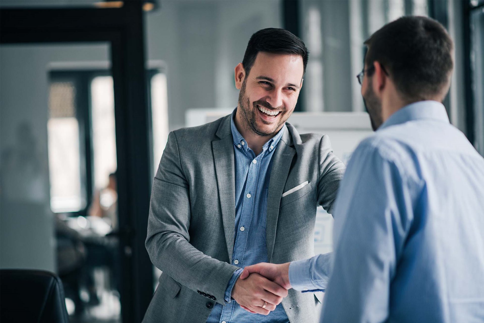 Two partners shaking hands over a business deal.