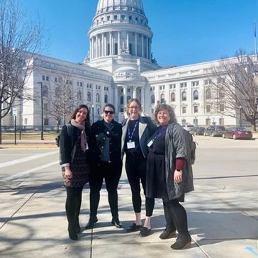 Four business women standing in front of the Wisconsin capitol building