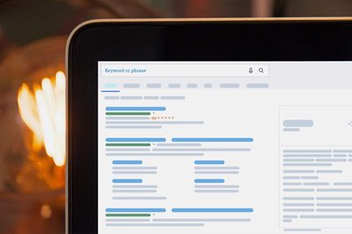 A close-up of a mockup of a search engine results page (SERP) on a laptop with a fireplace in the background. 