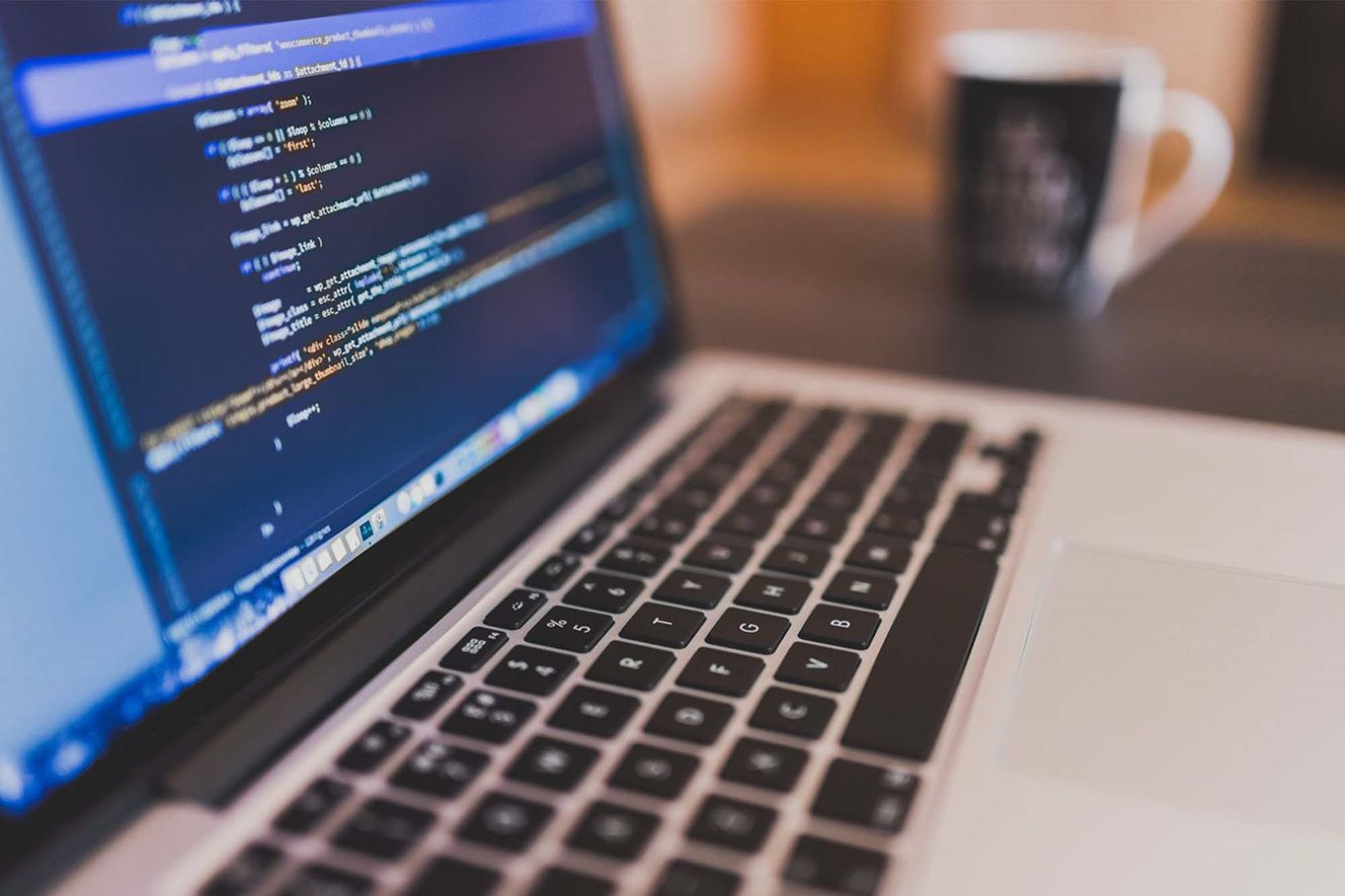 Web developer looking at code on a laptop