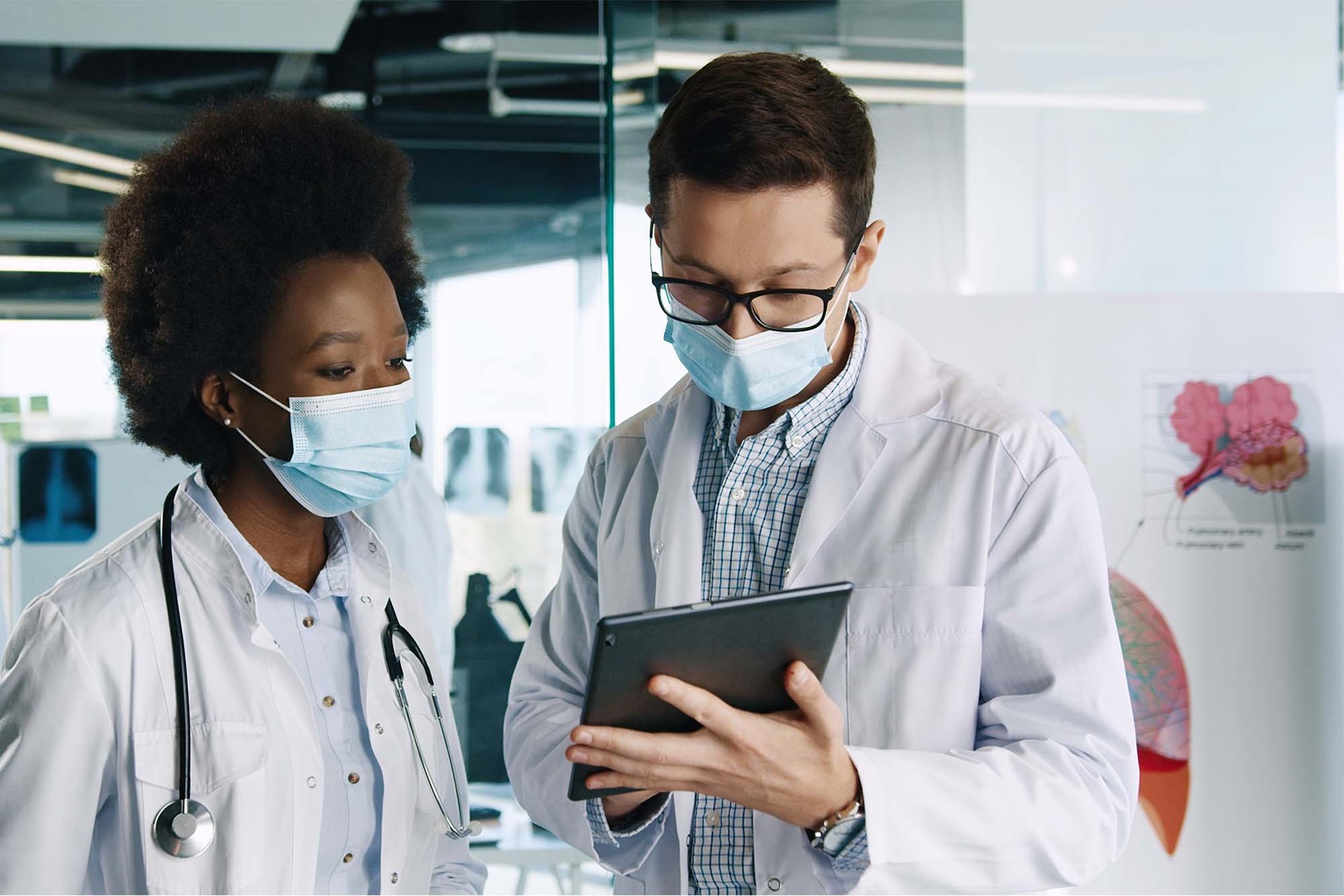 Two healthcare workers using a tablet for insights. 